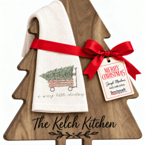 Tree-shaped engraved board with a kitchen towel in the A Merry Little Christmas (Tree in Wagon) design