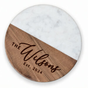 Set of four round marble and wood coasters engraved with a family name and year